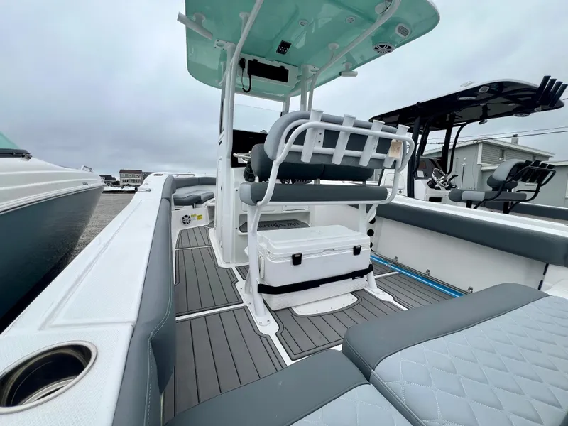 Slide: The Image of 2025 NauticStar 242OSL boat interior with gray seating and white cooler. - 9