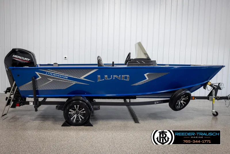 Slide: The Image of 2025 Lund 1775 Adventure SS boat in blue with Mercury engine, displayed indoors. - 3