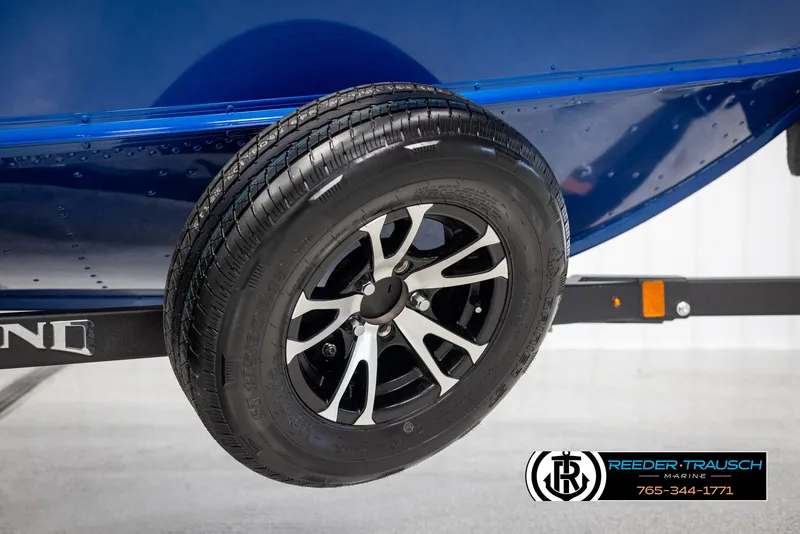 Slide: The Image of 2025 Lund 1775 Adventure SS boat trailer wheel, black and silver rim, Reeder-Trausch Marine logo. - 38