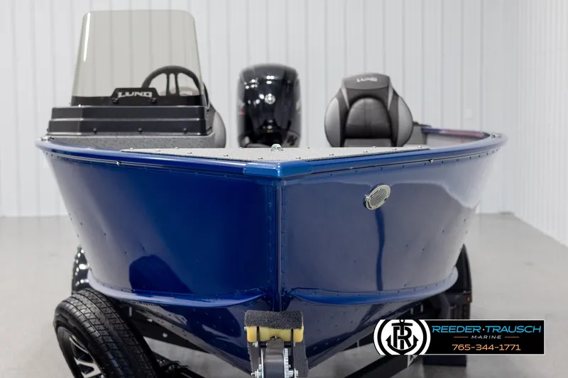 Slide: The Image of 2025 Lund 1775 Adventure SS boat, blue exterior, displayed indoors on a trailer. - 6