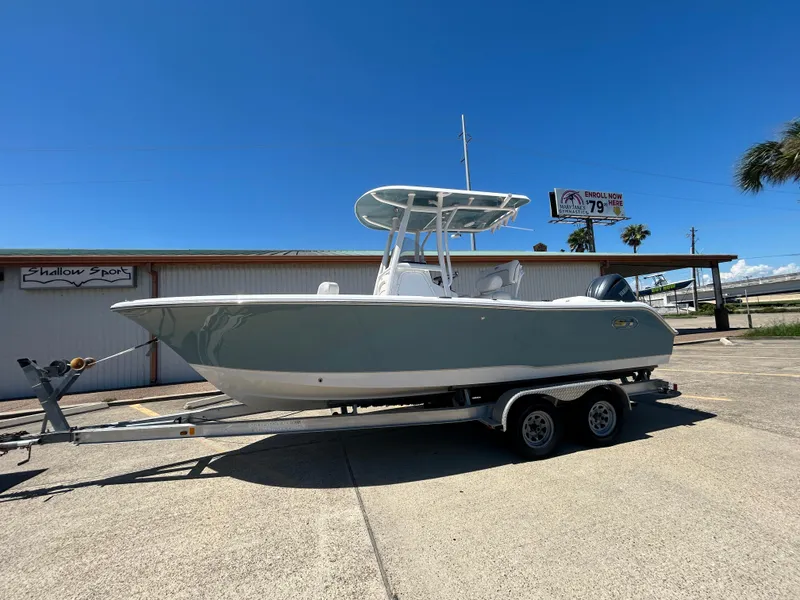 The Image of 2025 Sea Hunt Ultra 229 boat on trailer under clear blue sky. - 0