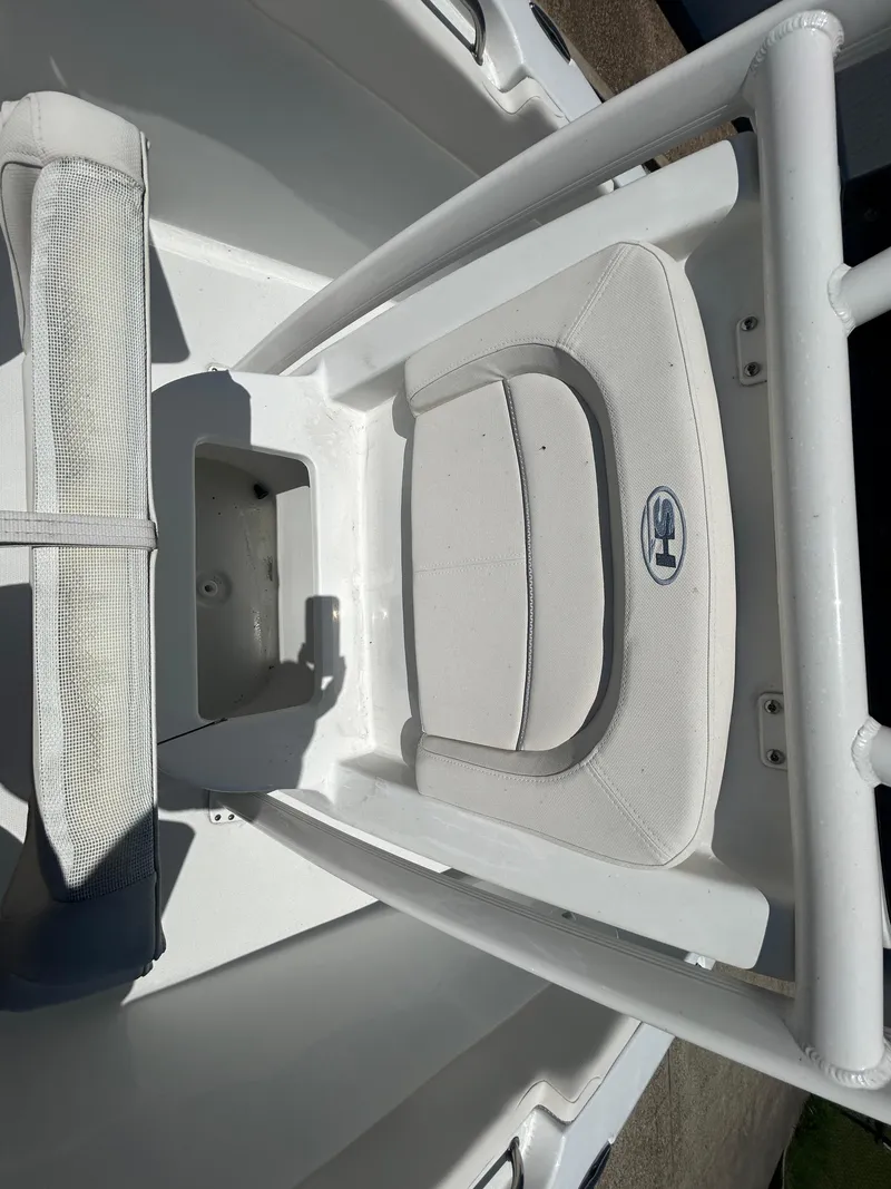 Slide: The Image of 2025 Sea Hunt Ultra 229 boat interior with cushioned seating and storage compartment. - 18
