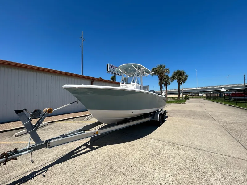 Slide: The Image of 2025 Sea Hunt Ultra 229 boat on trailer under clear blue sky. - 2