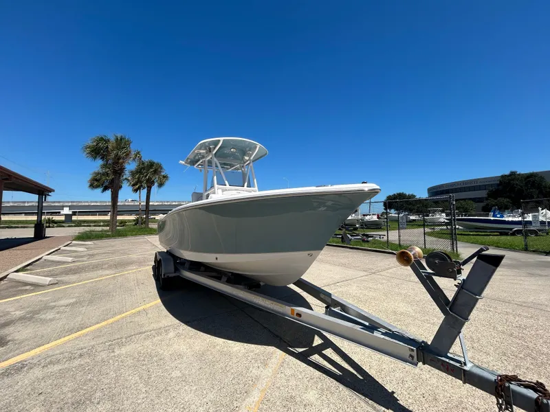 Slide: The Image of 2025 Sea Hunt Ultra 229 boat on trailer under clear blue sky. - 3