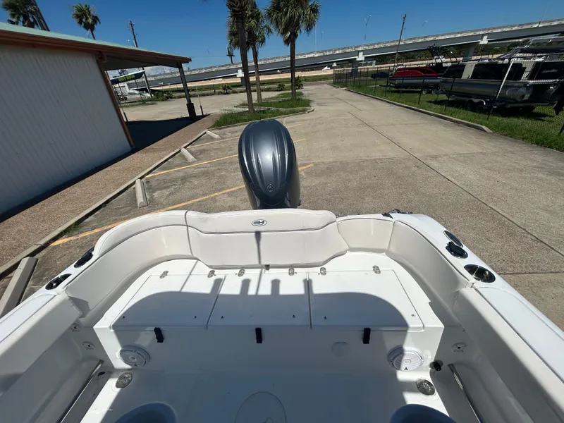 Slide: The Image of 2025 Sea Hunt Ultra 229 boat, rear view, parked outdoors under clear sky. - 7