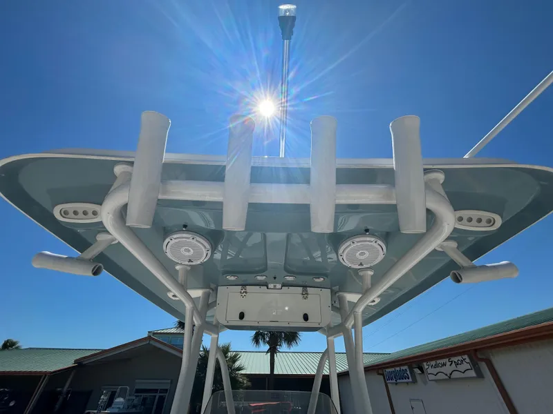 Slide: The Image of 2025 Sea Hunt Ultra 229 boat with rod holders and speakers under a sunny sky. - 8