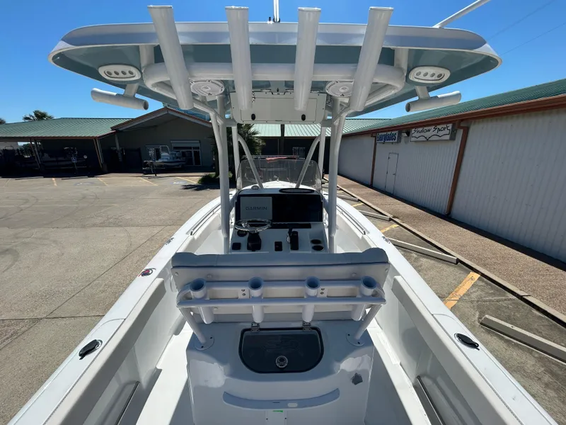 Slide: The Image of 2025 Sea Hunt Ultra 229 boat with center console and rod holders in a marina. - 9
