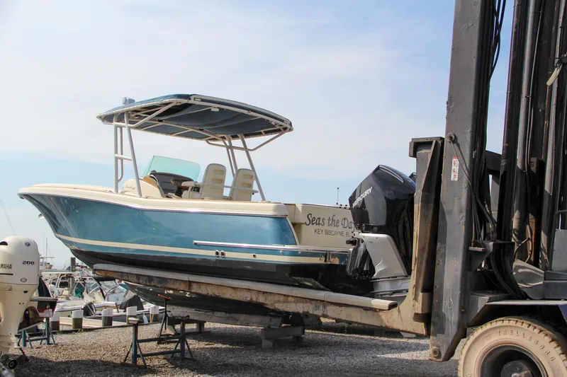 Slide: The Image of 2011 Chris-Craft Catalina 29 Sun Tender on forklift, blue hull, outdoor storage. - 11