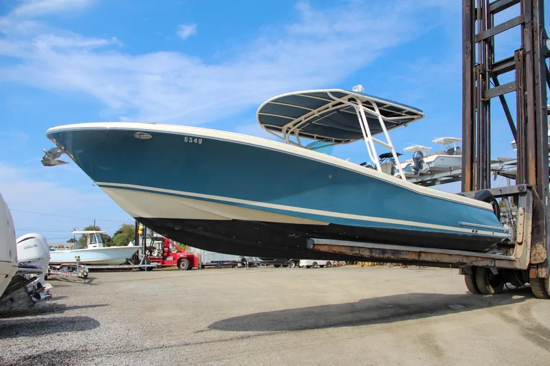 Slide: The Image of 2011 Chris-Craft Catalina 29 Sun Tender on forklift, blue hull, outdoor storage. - 13