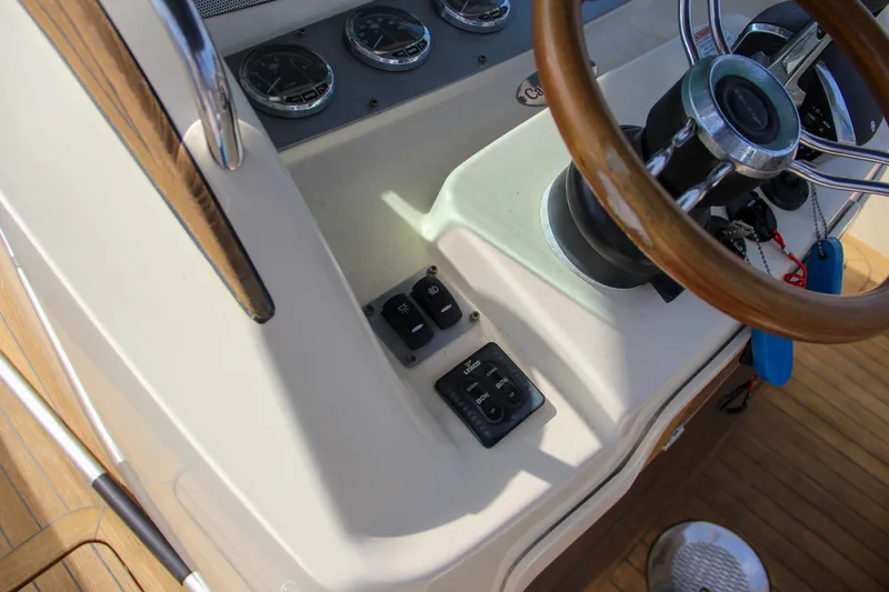 Slide: The Image of 2011 Chris-Craft Catalina 29 Sun Tender helm with steering wheel and control panel. - 25