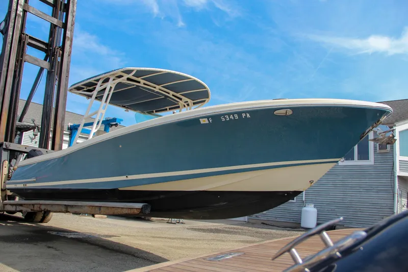Slide: The Image of 2011 Chris-Craft Catalina 29 Sun Tender boat on a lift, blue hull, sunny day. - 32