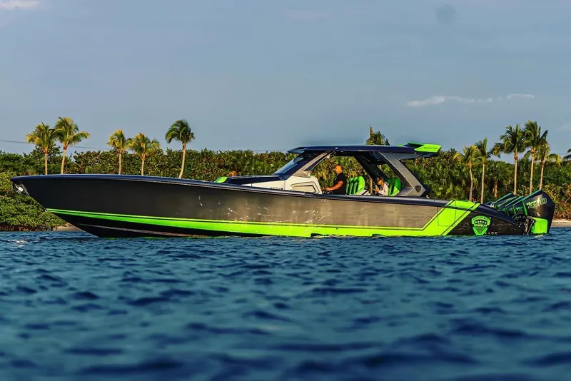 Slide: The Image of 2024 Adrenaline Reaper boat cruising on water with tropical backdrop. - 0