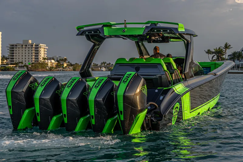 Slide: The Image of 2024 Adrenaline Reaper boat with five powerful engines, cruising near a coastal cityscape. - 1