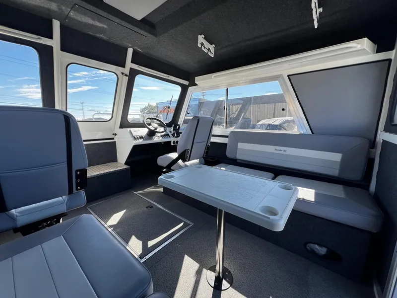 Slide: The Image of 2024 Thunder Jet 26 Alexis Pro XL interior with seating and table, showcasing modern design. - 18