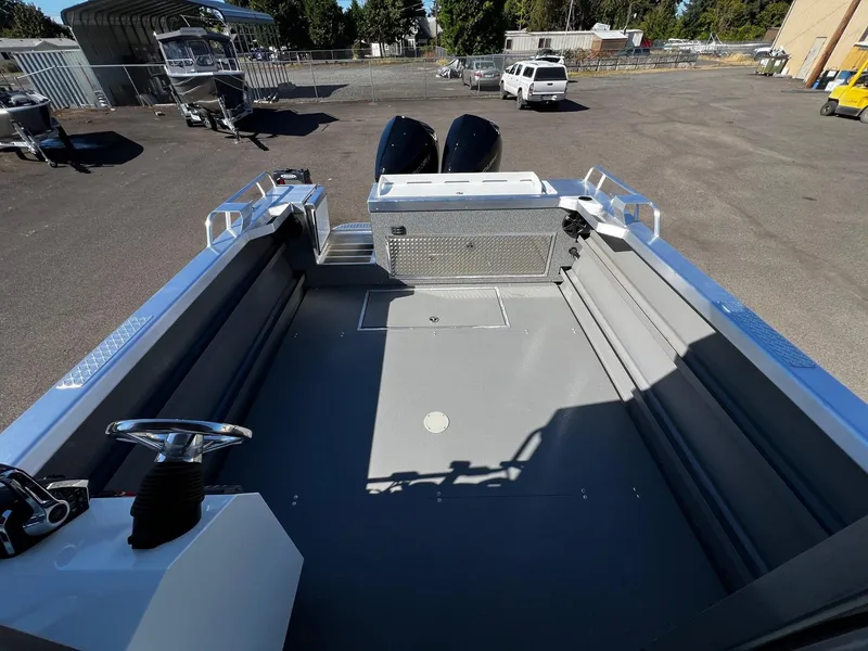 Slide: The Image of 2024 Thunder Jet 26 Alexis Pro XL boat interior, spacious deck, dual engines, parked outdoors. - 25