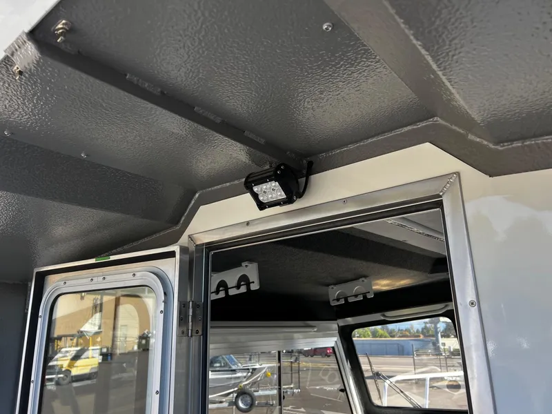 Slide: The Image of 2024 Thunder Jet 26 Alexis Pro XL interior, featuring a mounted light and window view. - 26