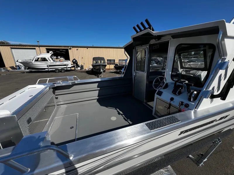 Slide: The Image of 2024 Thunder Jet 26 Alexis Pro XL boat, spacious deck, modern controls, parked outdoors. - 8