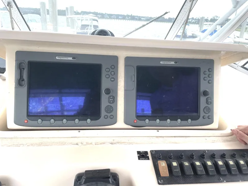Slide: The Image of 2008 Grady-White Open Express boat dashboard with dual navigation screens and control panel. - 15