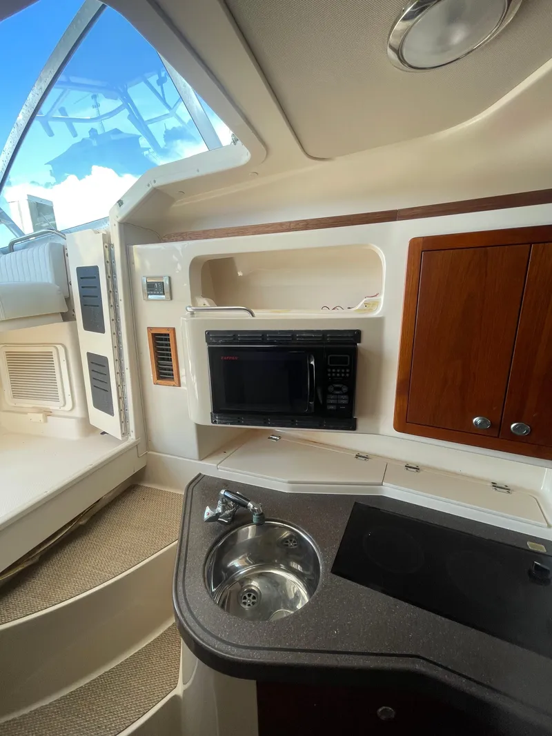 Slide: The Image of 2008 Grady-White Open Express boat interior with kitchenette, microwave, and sink. - 26