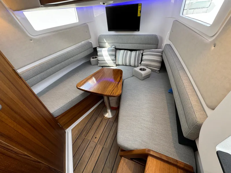 Slide: The Image of 2025 Southport 38 FE interior with modern seating, wooden table, and mounted TV. - 11