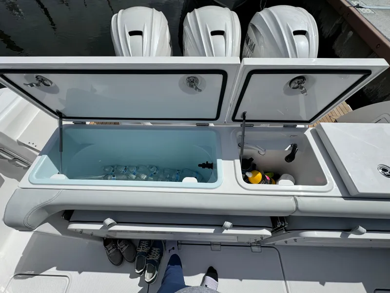 Slide: The Image of 2025 Southport 38 FE boat with open storage compartments and triple outboard engines. - 13