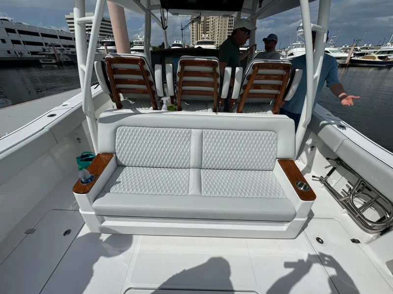 Slide: The Image of 2025 Southport 38 FE boat interior with cushioned seating and marina background. - 15