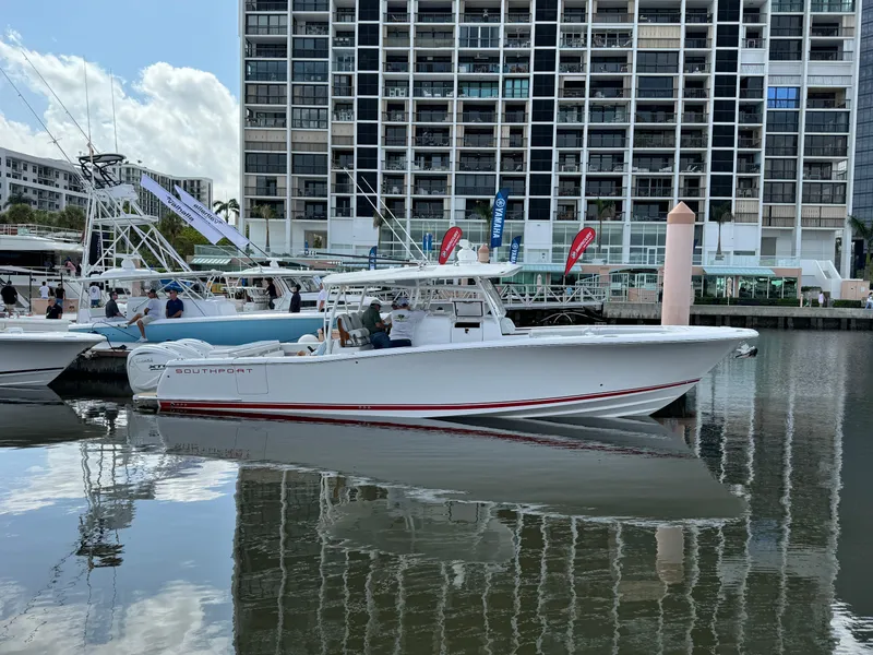 Slide: The Image of 2025 Southport 38 FE boat docked in marina, with modern buildings in the background. - 2