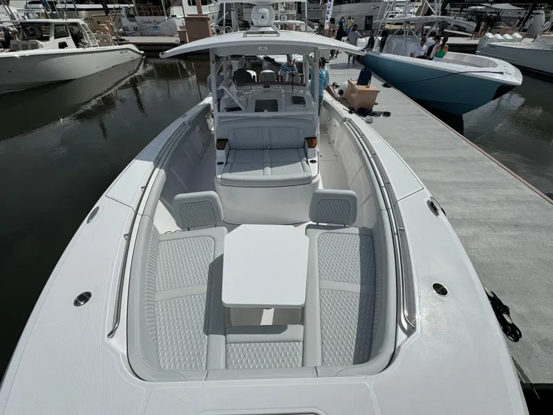 Slide: The Image of 2025 Southport 38 FE boat with spacious seating and sleek design at a marina. - 22