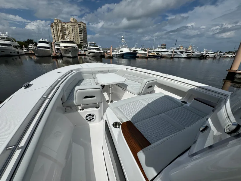 Slide: The Image of 2025 Southport 38 FE boat docked in marina with luxury seating and table. - 24