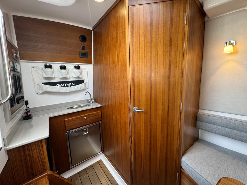 Slide: The Image of 2025 Southport 38 FE cabin interior with wood finish, kitchenette, and seating area. - 8