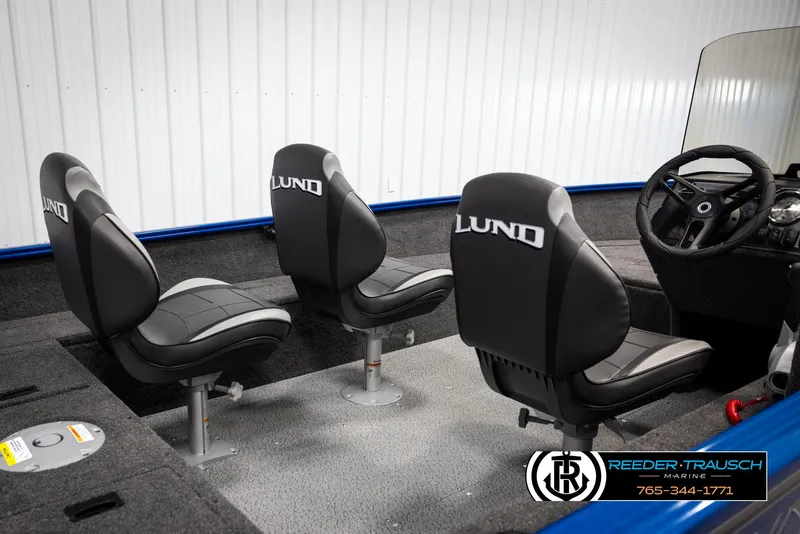 Slide: The Image of 2025 Lund Rebel XL SS boat interior with three black seats and steering console. - 11
