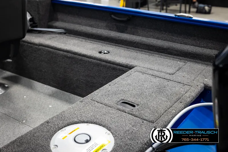 Slide: The Image of 2025 Lund Rebel XL SS boat interior with gray carpet and storage compartments. - 13