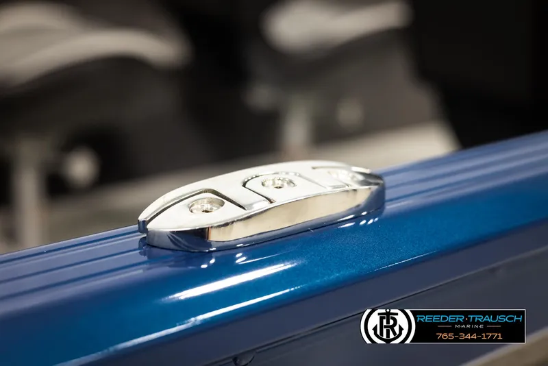Slide: The Image of 2025 Lund Rebel XL SS boat detail with chrome hardware, blue finish, Reeder-Trausch Marine logo. - 41