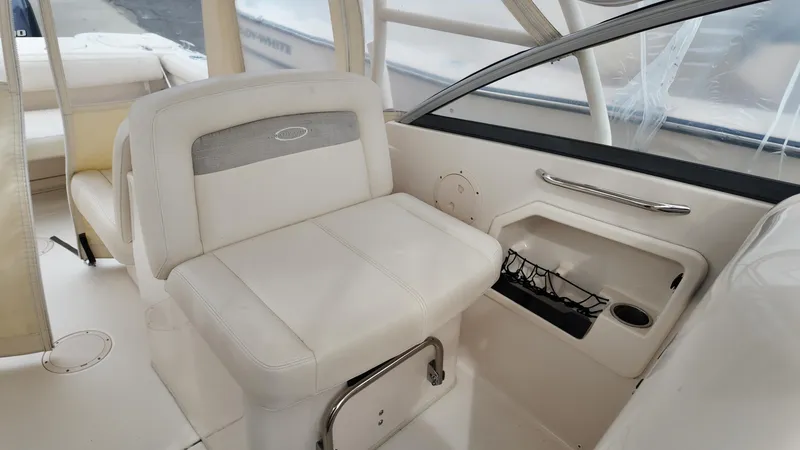 Slide: The Image of 2016 Grady-White Freedom 275 boat interior with white seating and storage compartment. - 15