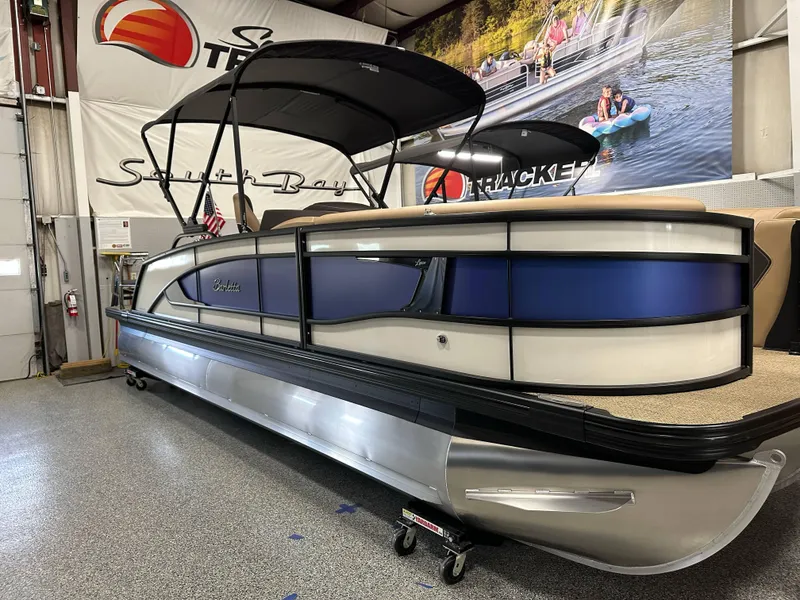 Slide: The Image of 2025 Barletta Lusso 23UC pontoon boat displayed indoors with canopy and sleek design. - 1