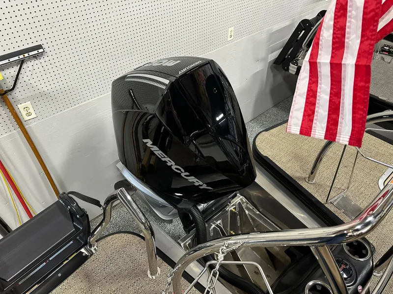 Slide: The Image of 2025 Barletta Lusso 23UC with Mercury outboard motor and American flag in a showroom. - 22
