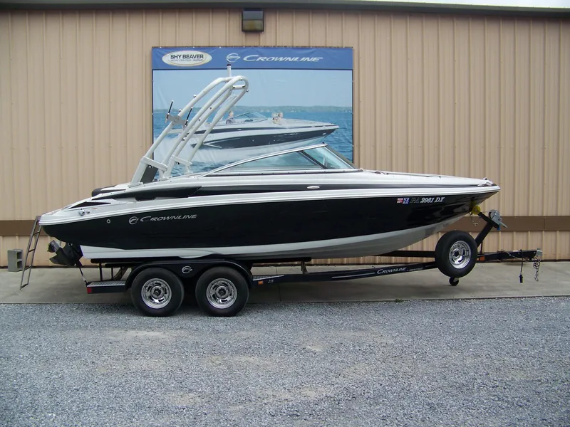 The Image of 2019 Crownline 215SS boat on trailer, parked outside a building. - 1