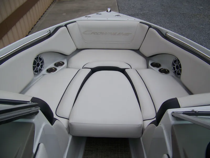 Slide: The Image of 2019 Crownline 215SS boat interior with white cushioned seating and cup holders. - 4