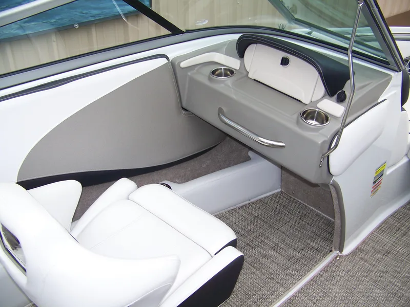 Slide: The Image of 2019 Crownline 215SS boat interior with white seating and cup holders. - 6