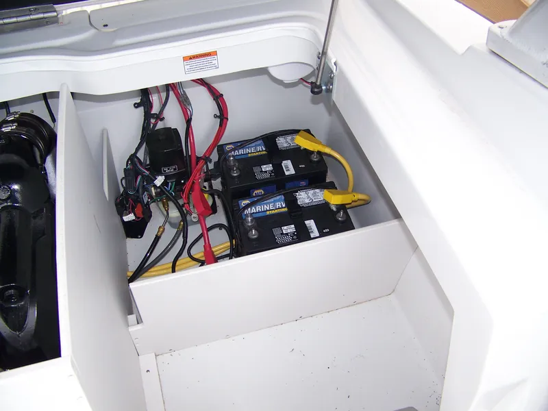 Slide: The Image of 2019 Crownline 215SS boat battery compartment with dual marine batteries and wiring. - 9