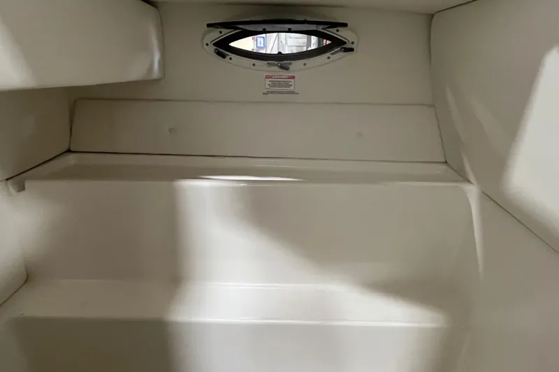 Slide: The Image of 2021 Bayliner VR6 Bowrider OB storage compartment with open lid and cup holders. - 10