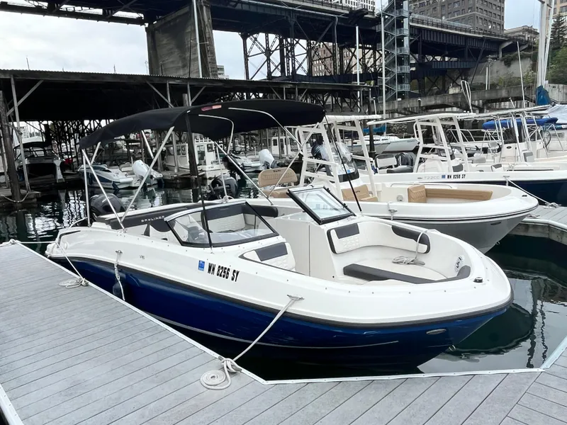 Slide: The Image of 2021 Bayliner VR6 Bowrider OB interior storage compartment with hand and foot visible. - 5