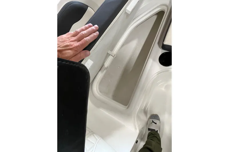 Slide: The Image of 2021 Bayliner VR6 Bowrider OB interior storage compartment with hand and foot visible. - 8