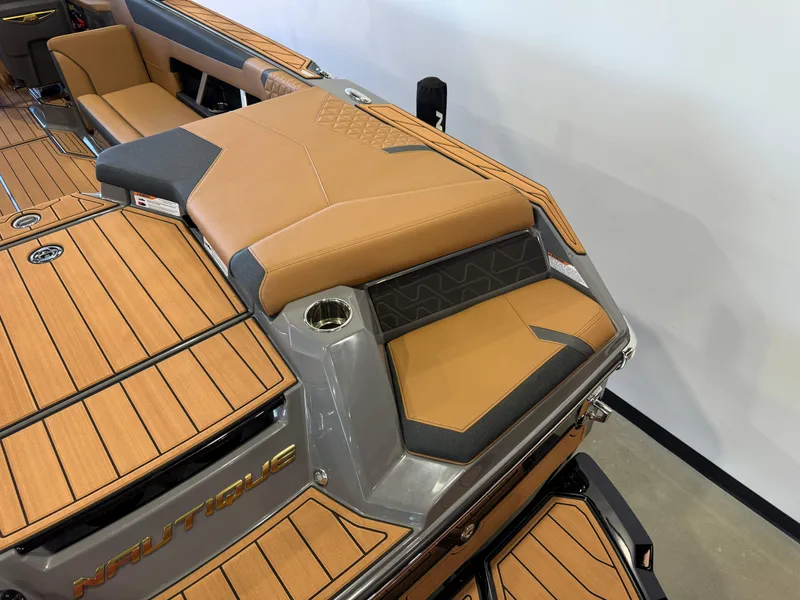 Slide: The Image of 2025 Nautique Super Air Nautique GS24 boat interior with tan and gray seating. - 11