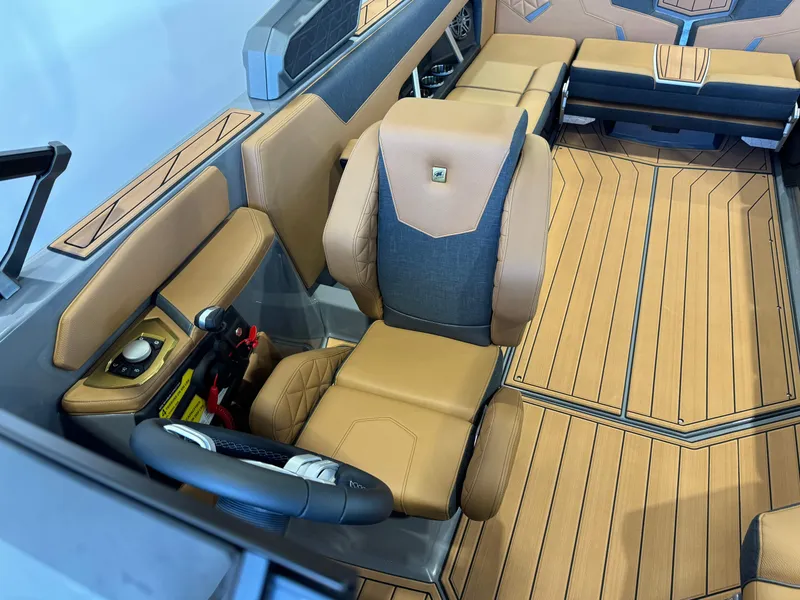 Slide: The Image of 2025 Nautique Super Air Nautique GS24 interior with tan and gray seating, modern helm design. - 21