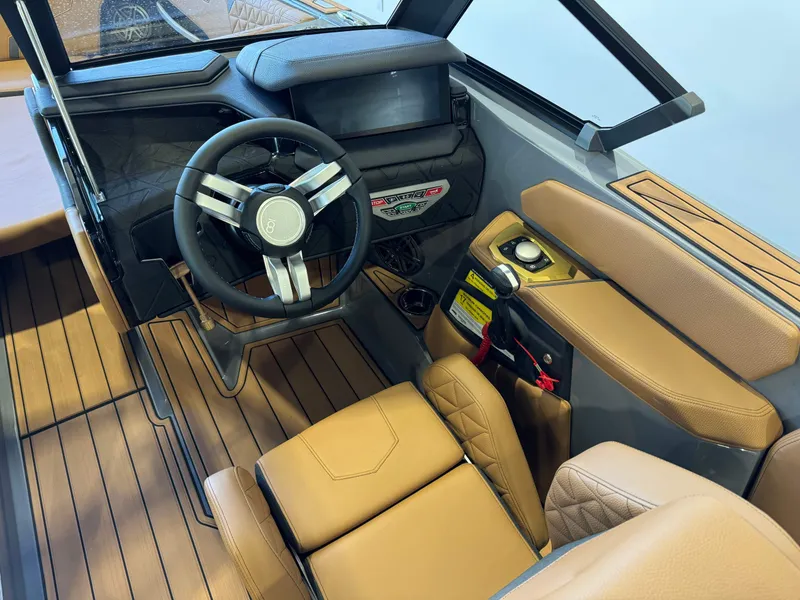 Slide: The Image of 2025 Nautique Super Air Nautique GS24 interior with tan leather seats and modern dashboard. - 26