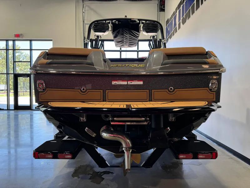 Slide: The Image of 2025 Nautique Super Air Nautique GS24 boat, rear view in showroom setting. - 6