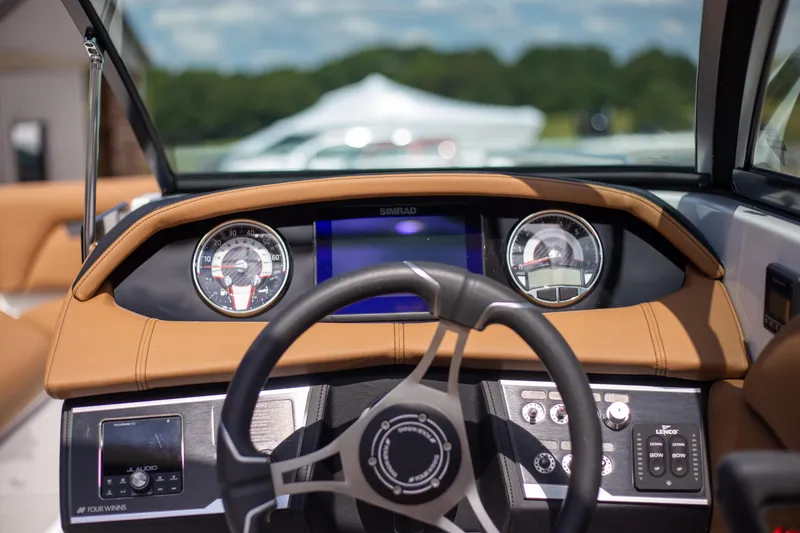 Slide: The Image of 2025 Four Winns HD5 boat dashboard with modern controls and steering wheel. - 12