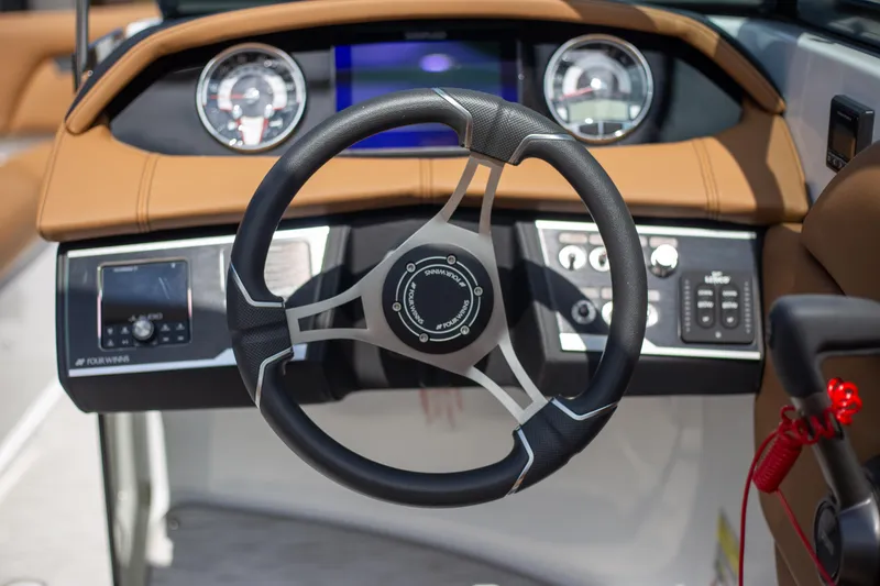 Slide: The Image of 2025 Four Winns HD5 boat dashboard with steering wheel and control panel. - 13