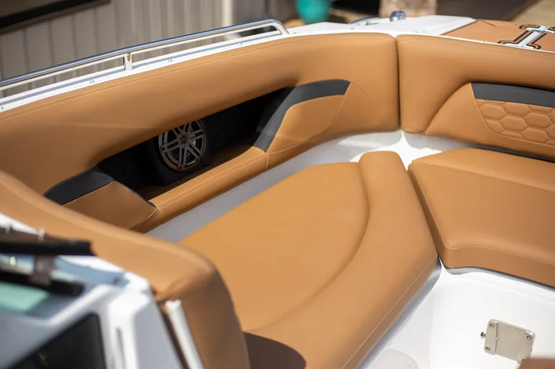 Slide: The Image of 2025 Four Winns HD5 boat interior with tan leather seating and built-in speaker. - 16